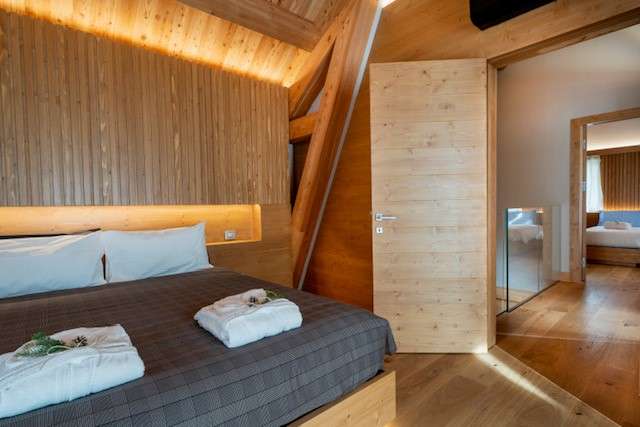 Camera matrimoniale con illuminazione a Led sotto il letto dello Chalet Lavinal Dal Ors del Kile Alpine resort a Valbruna nella Val Saisera in provincia di Udine